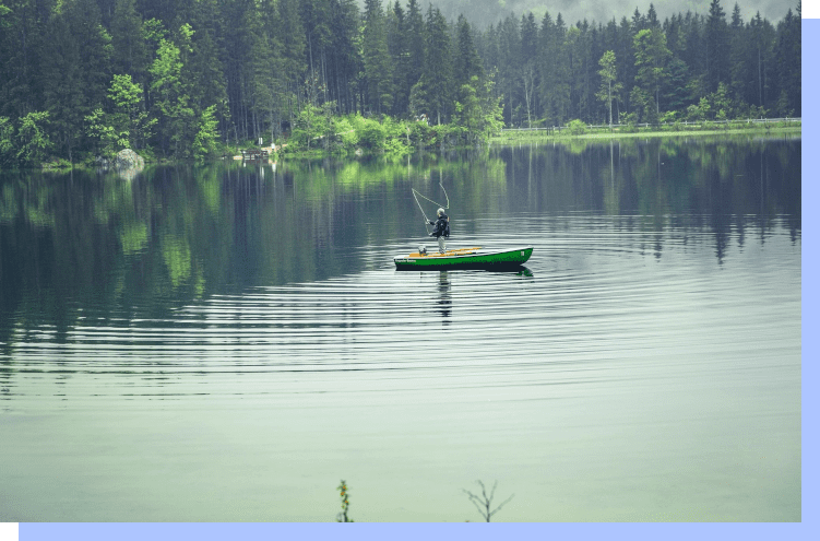 A person in a green boat on the water.